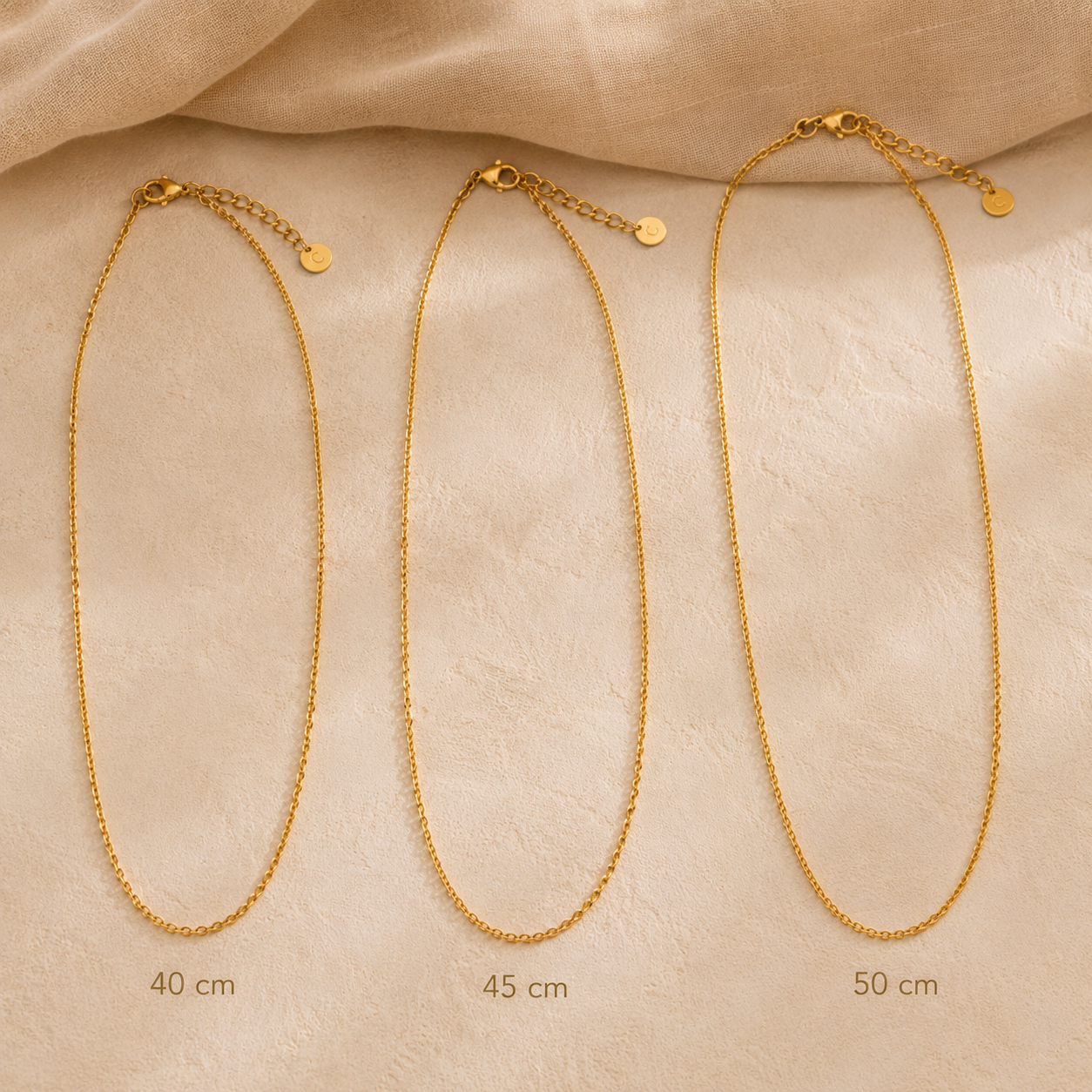 Comparaison des longueurs 40 cm, 45 cm et 50 cm d’un collier personnalisé doré sur fond crème premium.