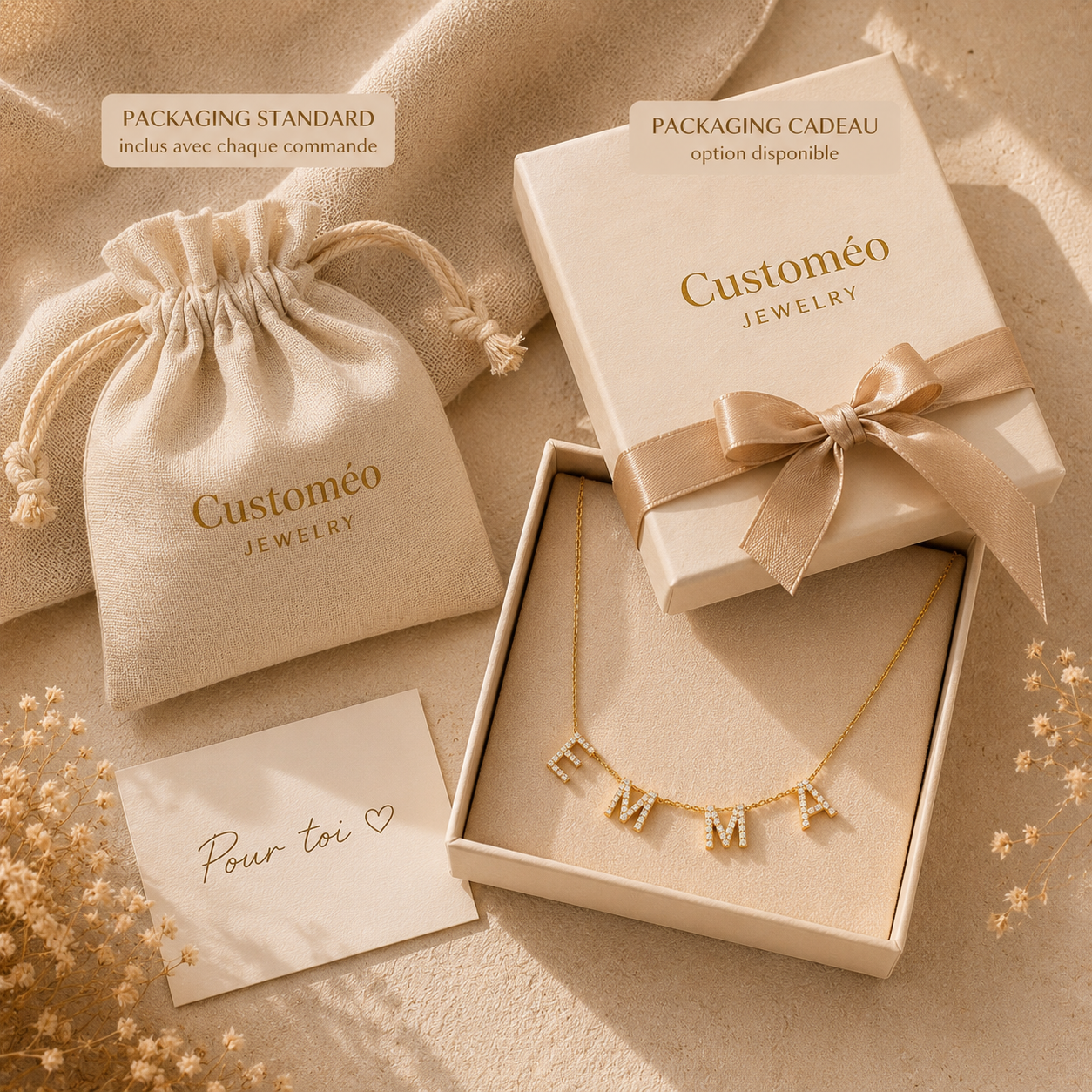 Packaging cadeau premium avec collier personnalisé prénom EMMA en lettres dorées serties de strass, pochon coton et carte message manuscrit.